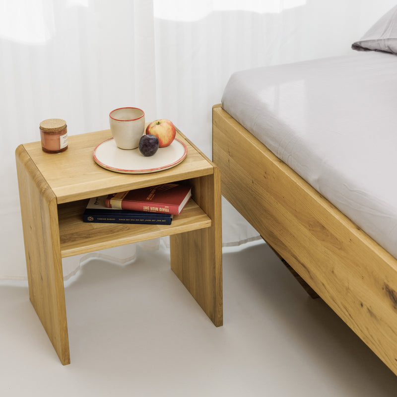 Designer Nachttisch aus robustem Eichenholz neben zeitlosem Schwebebett