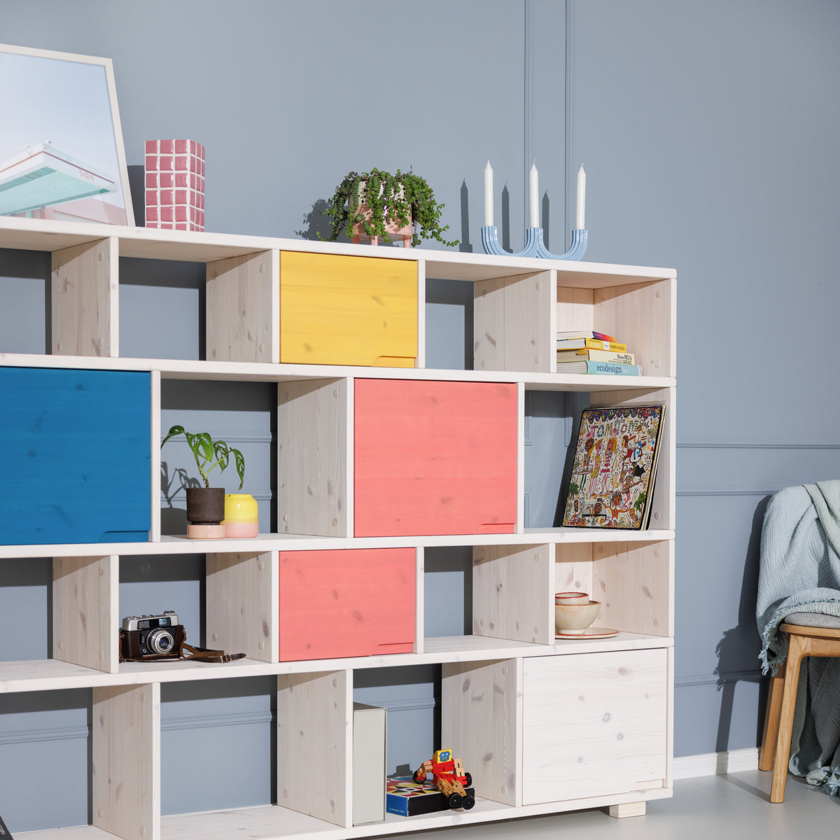 Weißes Bücherregal aus Massivholz mit blauen, roten, gelben Türen